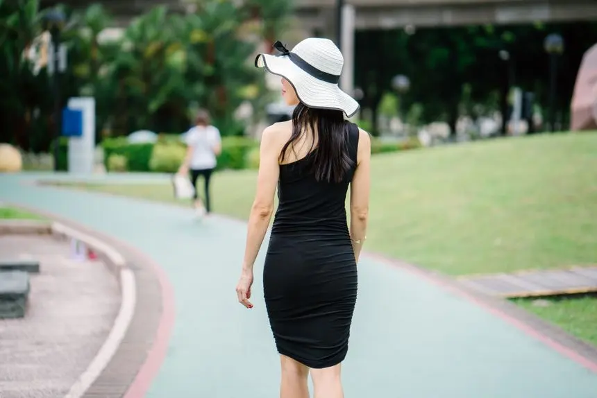 Woman walking outdoors on a park path, the kind of daily movement that helps the calf muscles pump fluid out of the legs